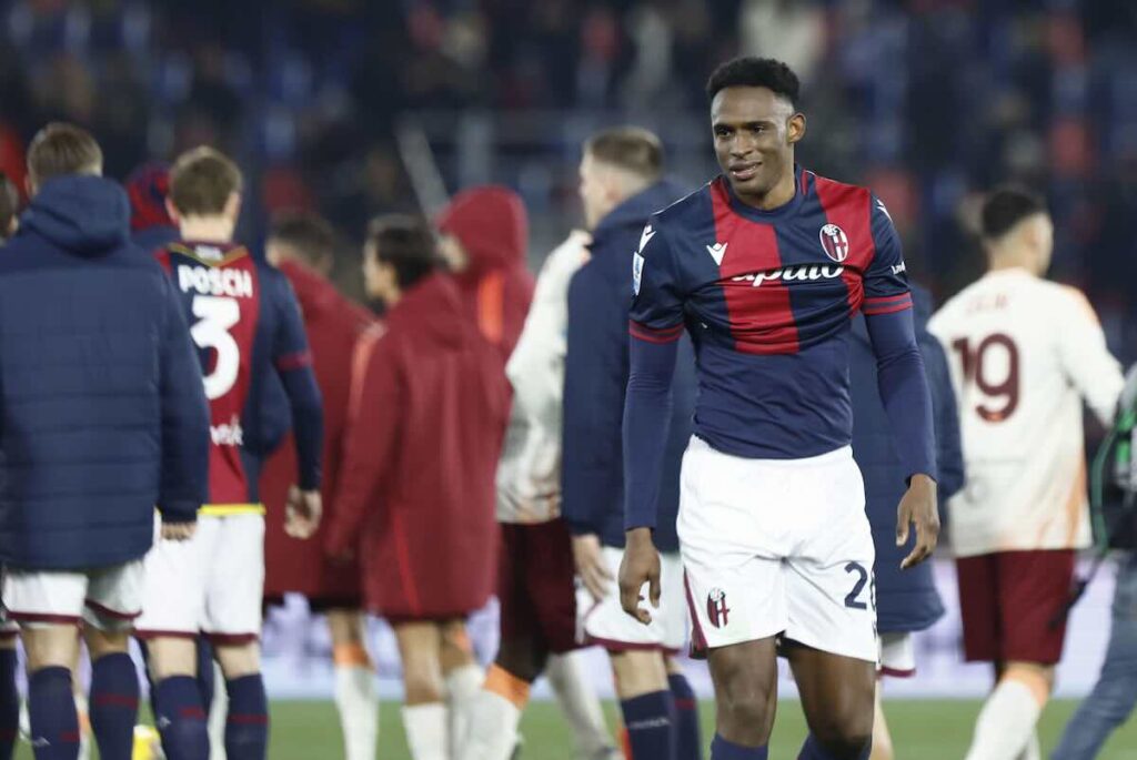 Lucumì difensore del Bologna durante una partita, con maglia blu e rossa a righe