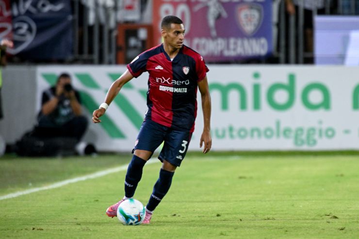 Riyad Idrissi del Cagliari in azione durante una partita di Serie A. Il terzino sinistro rossoblù controlla il pallone in fase di costruzione.