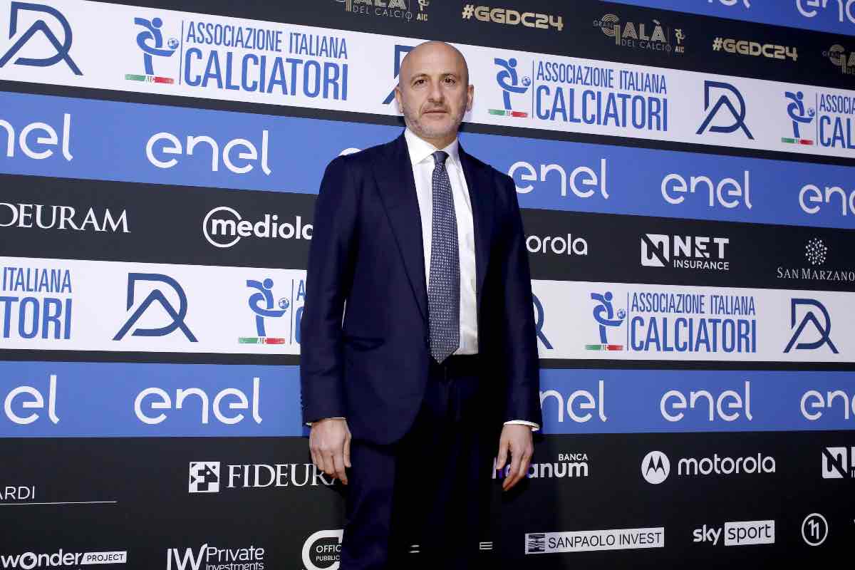 Piero Ausilio, direttore sportivo dell'Inter, posizionato davanti ai loghi ufficiali dell'Associazione Italiana Calciatori, durante un evento pubblico