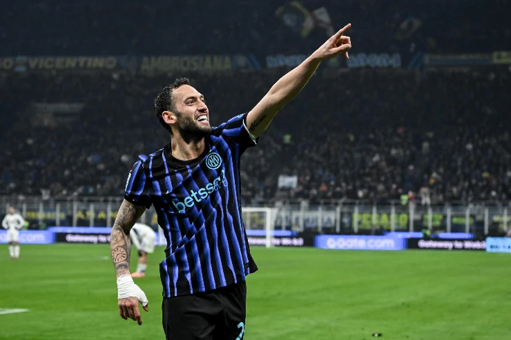 Hakan Calhanoglu esulta durante una partita dell'Inter, con il braccio teso verso il pubblico dello stadio