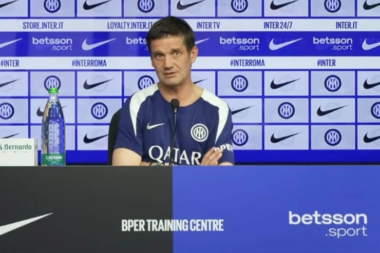 Cristian Chivu durante una conferenza stampa all'Inter Training Centre con lo stemma dell'Inter sullo sfondo