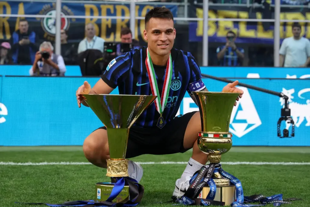 Lautaro Martinez con Scudetto e Coppa Italia al centro del campo