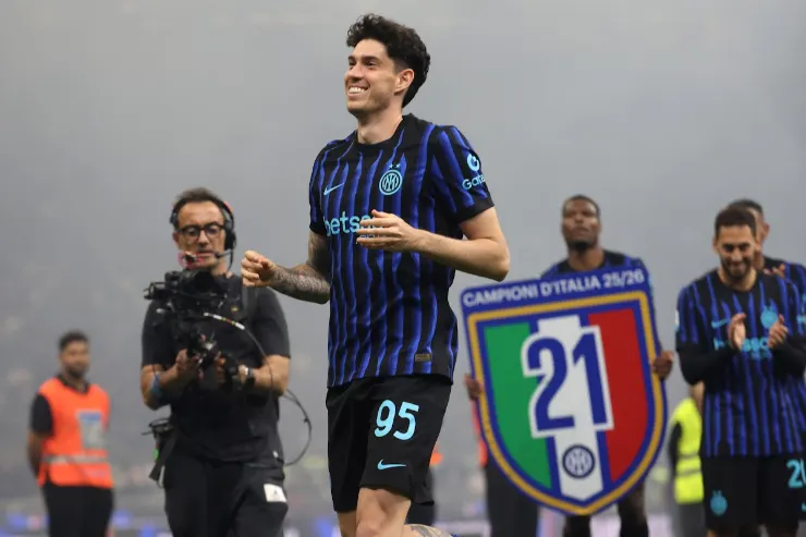 Bastoni sorride durante una celebrazione con la maglia dell'Inter a righe blu e nere, numero 95