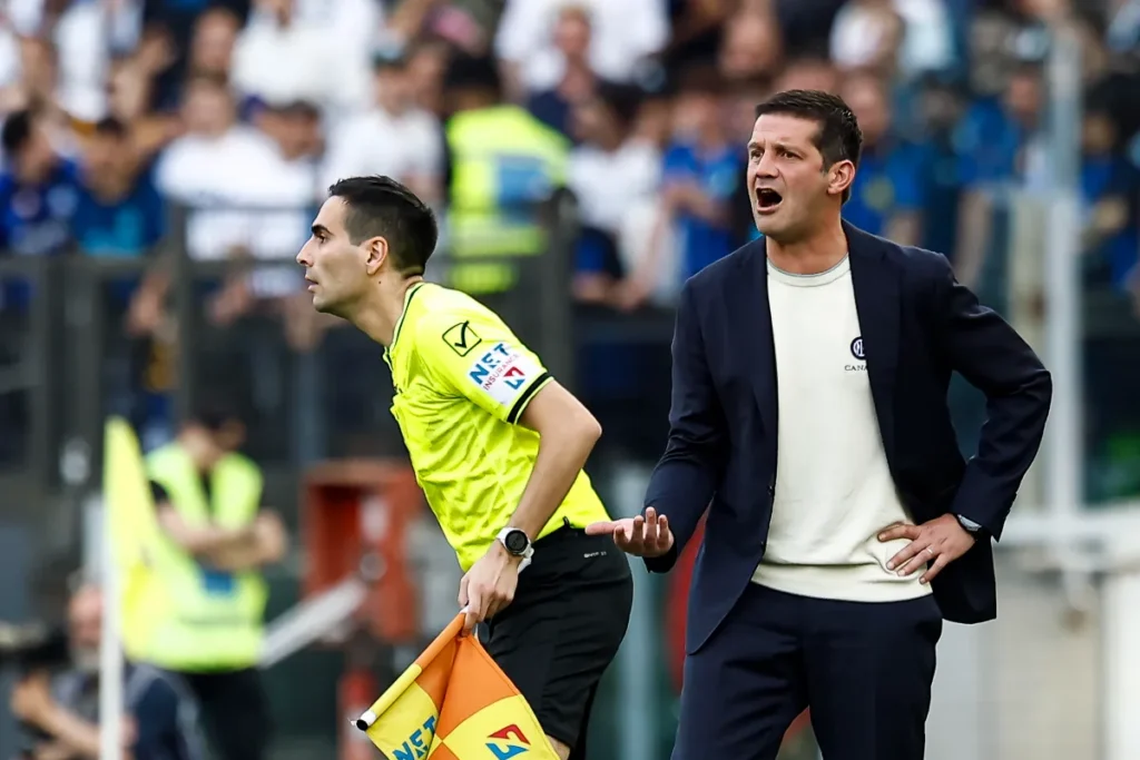 Chivu gesticola dalla panchina dell'Inter durante una partita, accanto all'arbitro in divisa gialla