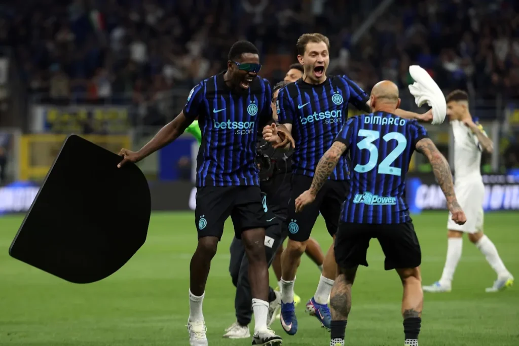 Dimarco, Barella e Thuram dell'Inter celebrano in campo con la maglia nerazzurra a righe blu e nere