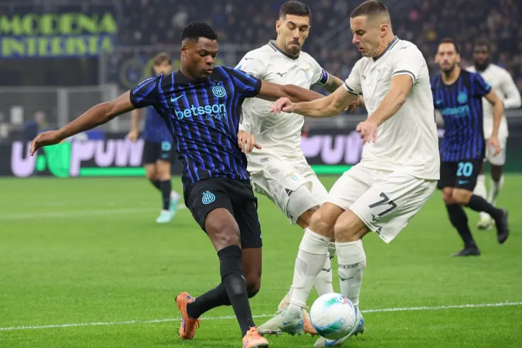 Dumfries in azione durante una partita, contrasta il pallone con un avversario in maglia bianca