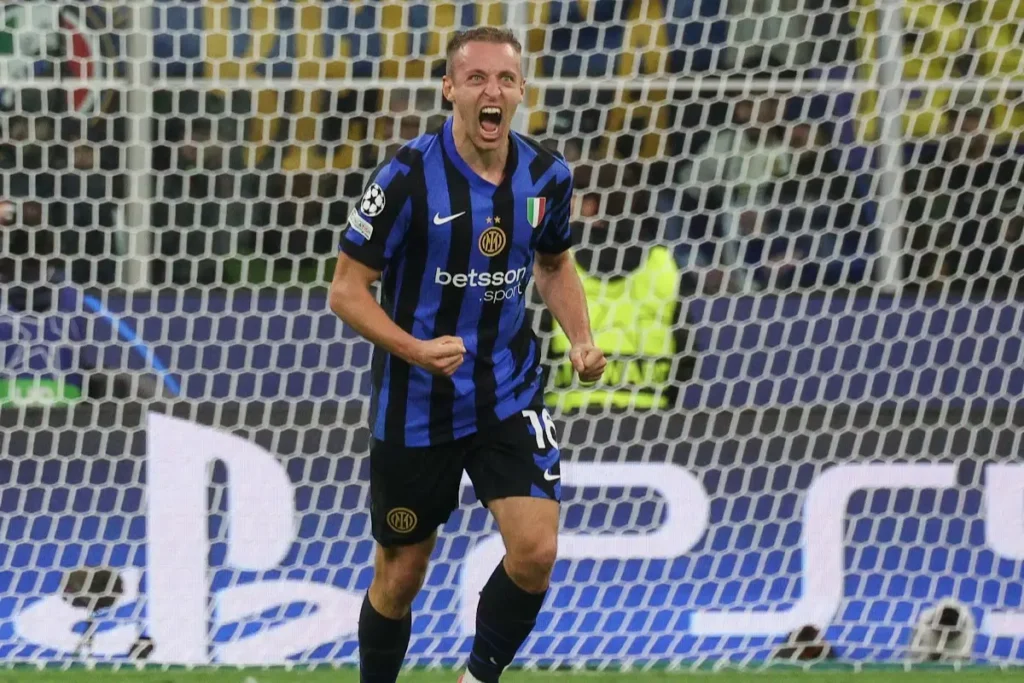 Davide Frattesi esulta durante una partita dell'Inter, indossando la maglia nerazzurra a strisce con sponsor Betsson