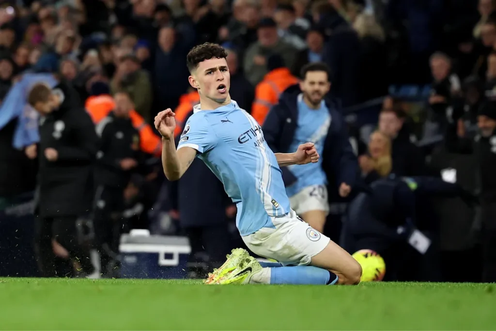 Phil Foden del Manchester City in azione durante una partita, con lo stadio sullo sfondo