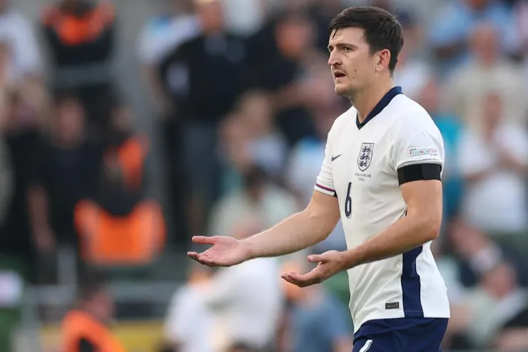 Harry Maguire in maglia Inghilterra durante una partita, con espressione di comunicazione in campo