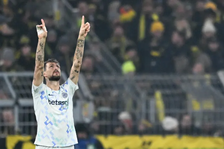 Francesco Acerbi in maglia bianca celebra con le braccia alzate durante una partita di calcio