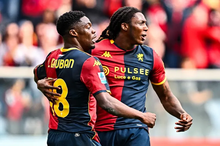 Giocatori in azione durante una partita di calcio, con maglia a strisce rosse e blu