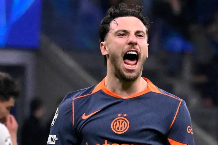 Carlos Augusto celebra durante una partita, indossa la maglia dell'Inter blu e arancione
