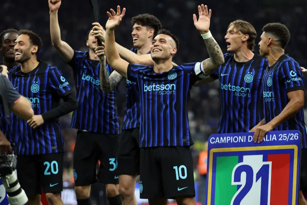 Giocatori dell'Inter esultano in campo con lo scudetto Campioni d'Italia, indossando le maglie nerazzurre a strisce