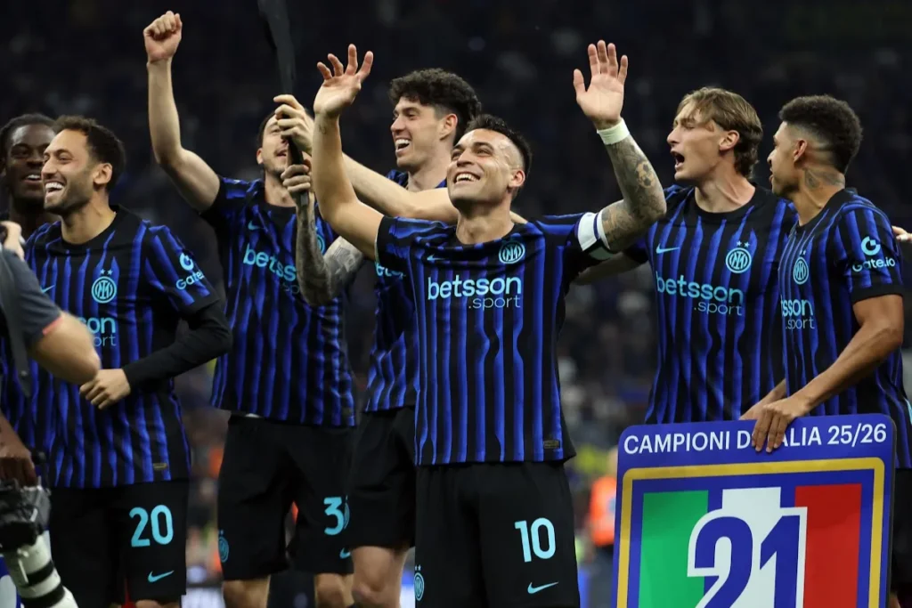 Giocatori dell'Inter celebrano la vittoria con le braccia alzate, indossando la maglia a righe nerazzurre con sponsor Betsson