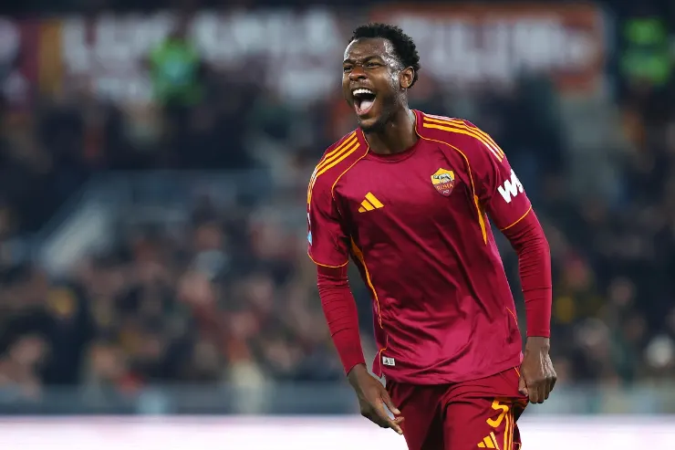 Evan N'Dicka esulta durante una partita, indossa la maglia giallorossa con strisce gialle della Roma