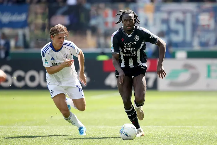 Giocatore in maglia bianca e nera durante una partita di calcio in campo
