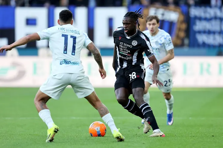 Lys Mousset in azione durante una partita di calcio, con pallone in possesso e avversario in marcatura
