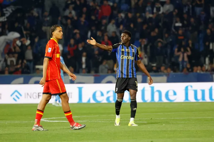 Akinsanmiro in maglia Inter a righe blu e nero durante una partita, con avversario in rosso sullo sfondo dello stadio