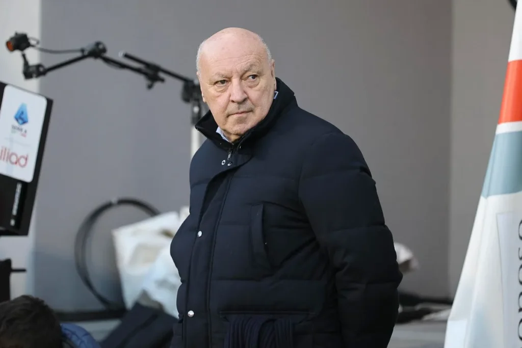Beppe Marotta in giubbotto nero durante un evento ufficiale con allestimento mediatico