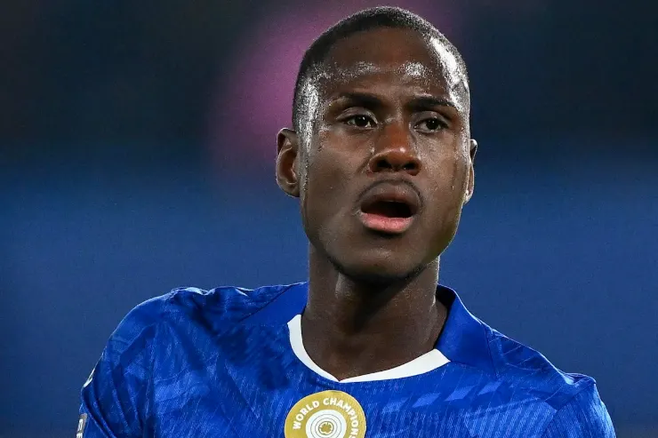 Giocatore in maglia azzurra durante una partita, primo piano del volto con sfondo sfumato blu