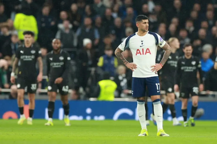 Cristian Romero in maglia Tottenham durante una partita, in piedi in mezzo al campo con le mani sui fianchi