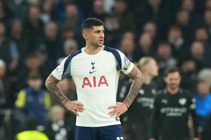 Cristian Romero in maglia Tottenham durante una partita, con le mani sui fianchi in campo