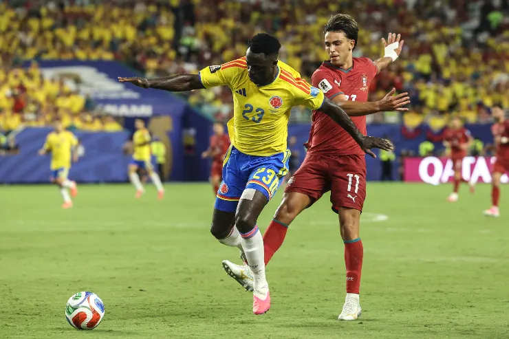Giocatore della Colombia numero 23 in maglia gialla contrasta con difensore del Portogallo numero 11 in maglia rossa durante partita di calcio
