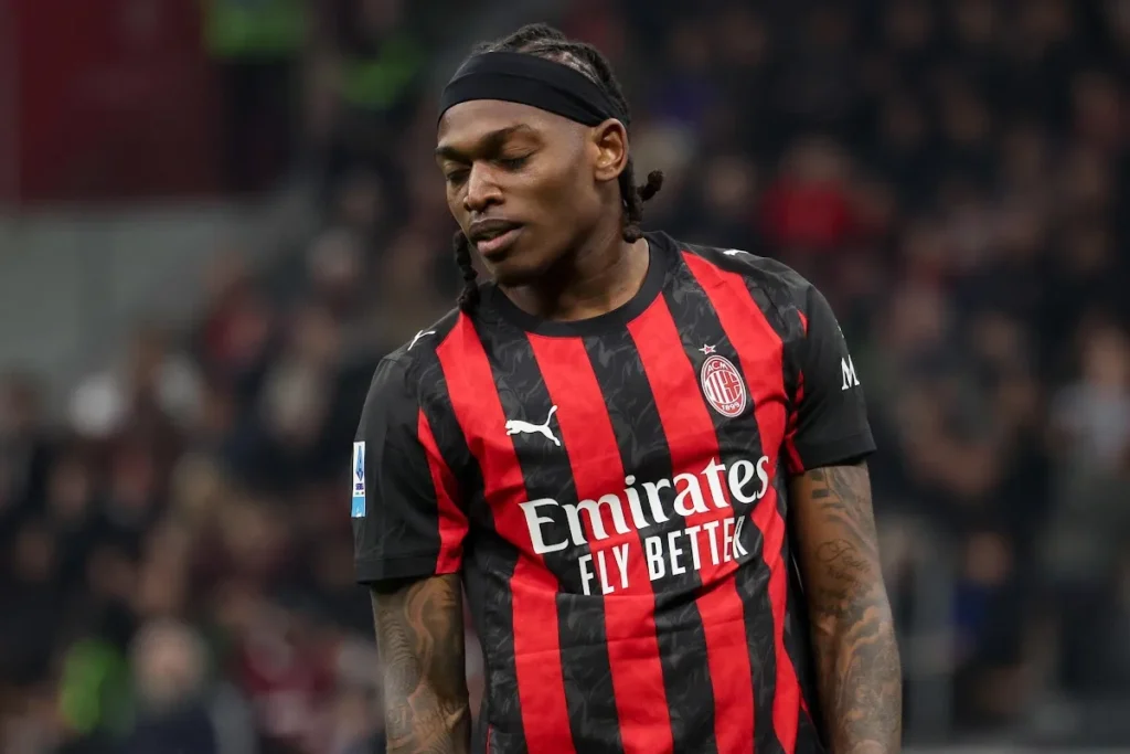 Rafael Leao in maglia AC Milan durante una partita, con fascia nera e sponsor Emirates