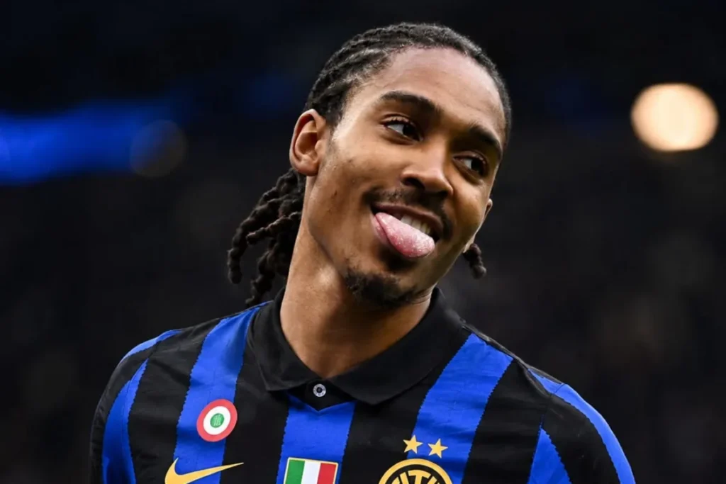 Giocatore dell'Inter sorride durante una partita indossando la maglia nerazzurra con due stelle