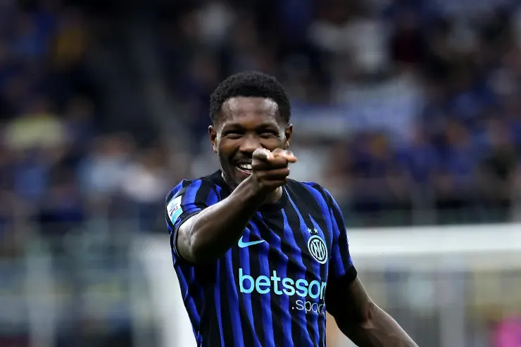 Marcus Thuram con la maglia dell'Inter esulta durante una partita, indossando la divisa nerazzurra a strisce blu e nere
