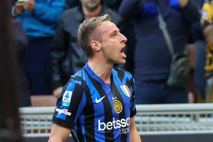 Davide Frattesi in divisa Inter a strisce blu e nere durante una partita, ripreso di profilo con espressione concentrata