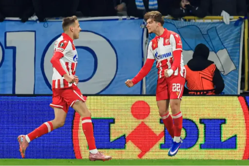 Kostov in maglia Stella Rossa durante una partita, con compagni di squadra sullo sfondo