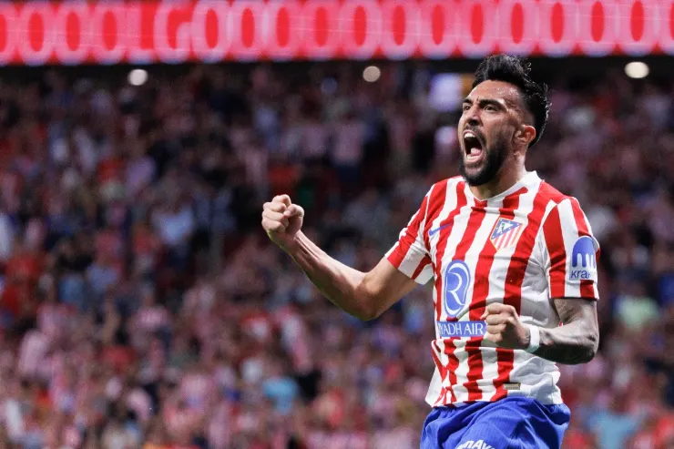 Nico Gonzalez esulta in campo indossando la maglia dell'Atletico Madrid a strisce rosse e bianche