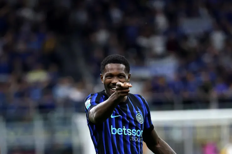 Marcus Thuram esulta durante una partita dell'Inter, indossando la maglia nerazzurra a righe