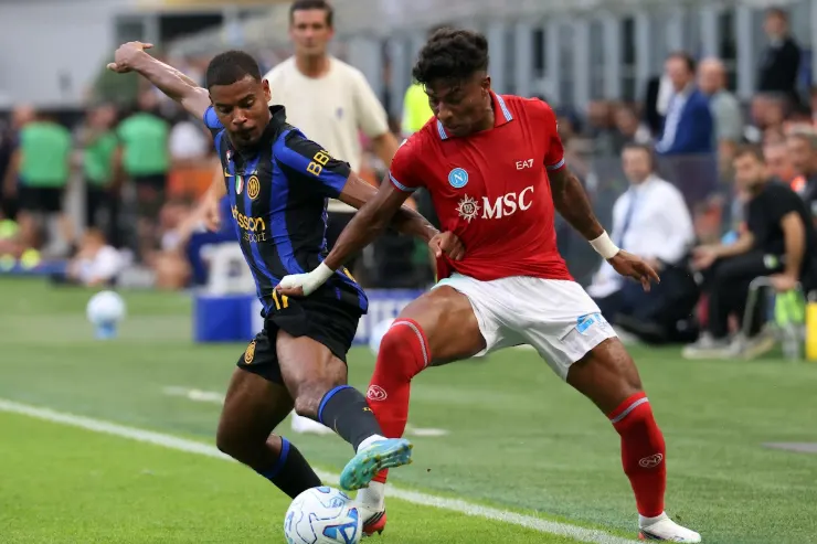Alisson dell'Inter in maglia blu e nera contrasta con un avversario in maglia rossa durante una partita di calcio