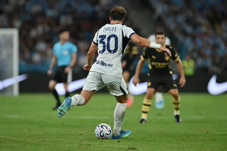 Carlos Augusto con pallone durante la partita, maglia bianca numero 30
