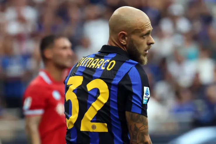 Dimarco indossa la maglia dell'Inter a righe blu e nero durante una partita