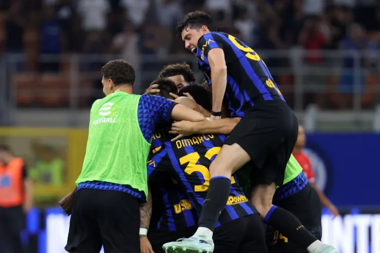 Giocatori dell'Inter esultano insieme durante una partita, abbracciati in campo indossando la maglia nerazzurra