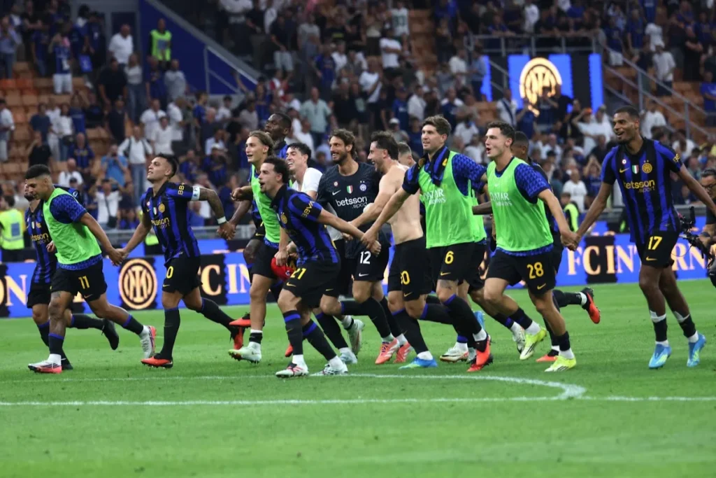 Squadra dell'Inter corre insieme sul campo durante una partita di Serie A, con i giocatori in divisa nerazzurra e casacche verdi
