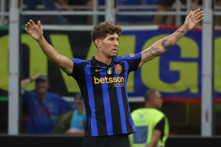 John Stones in maglia Inter, braccia alzate durante una partita allo stadio