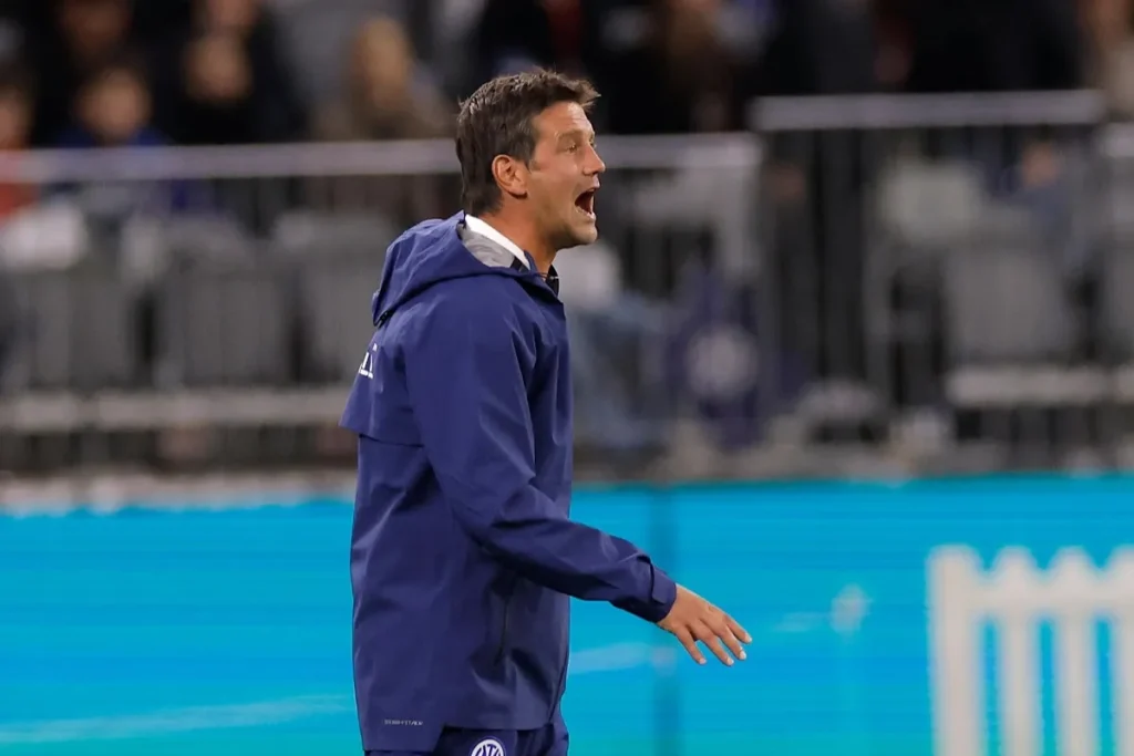 Cristian Chivu, allenatore dell'Inter, urla indicazioni a bordocampo indossando una giacca blu