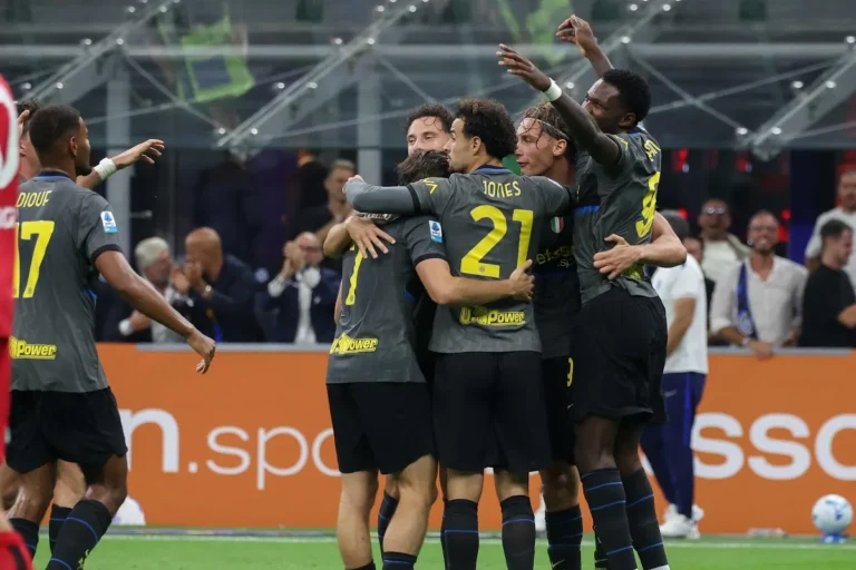 Giocatori dell'Inter in maglia grigia abbracciati ed esultanti dopo un gol, con il logo UniPower sulle divise