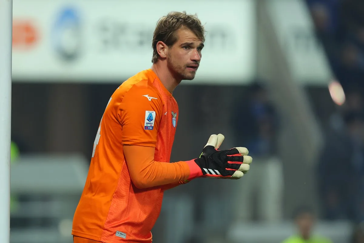 Portiere con maglia arancione Mizuno e stemma Lazio, patch Serie A TIM e guanti neri e bianchi durante una partita