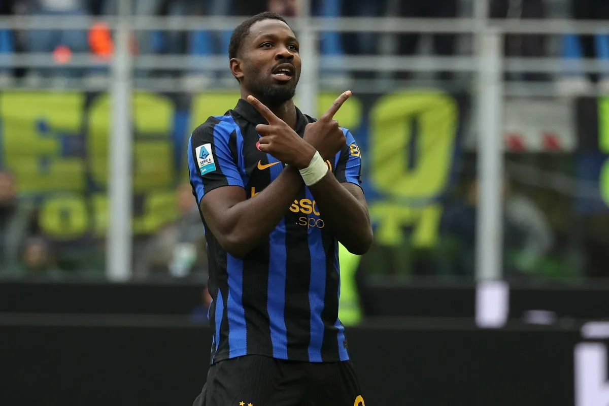 Marcus Thuram con la maglia nerazzurra a strisce esulta incrociando le dita davanti allo stadio