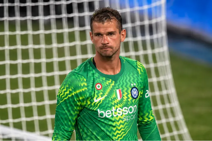 Provedel in divisa da portiere dell'Inter, indossa una maglia verde brillante con motivo ondulato, posizionato davanti alla rete