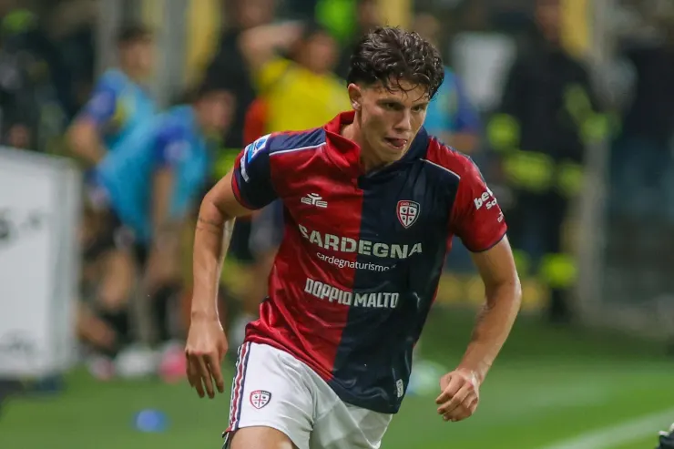 Giocatore in maglia Cagliari con nome Sardegna durante una partita di calcio