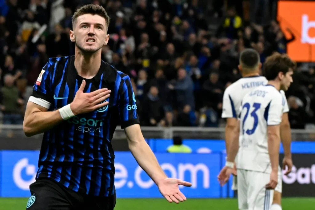 Giocatore dell'Inter in maglia nerazzurra a strisce blu durante una partita in stadio