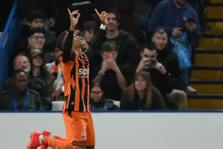 Pedrinho dello Shakhtar Donetsk con maglia arancione e nera esulta a braccia alzate davanti ai tifosi